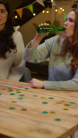 Vertical-Video-Of-Group-Of-Friends-At-Home-Or-In-Bar-Celebrating-At-St-Patrick's-Day-Party-Drinking-Alcohol-And-Doing-Cheers-Together-1